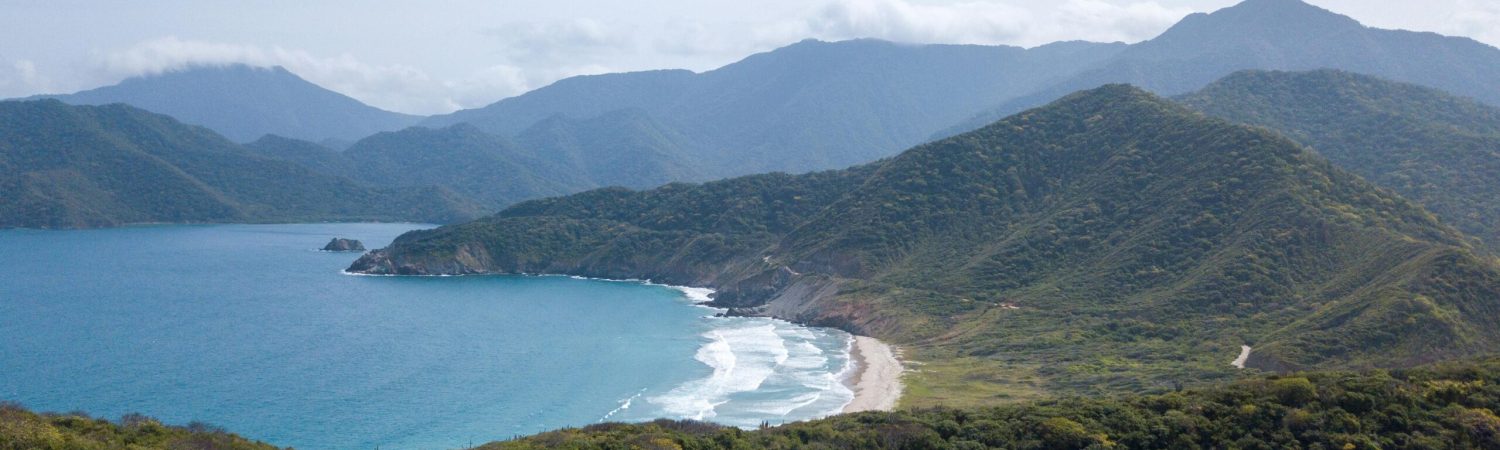 A breathtaking aerial view of Tayrona National Park's coastline with lush greenery and ocean waves