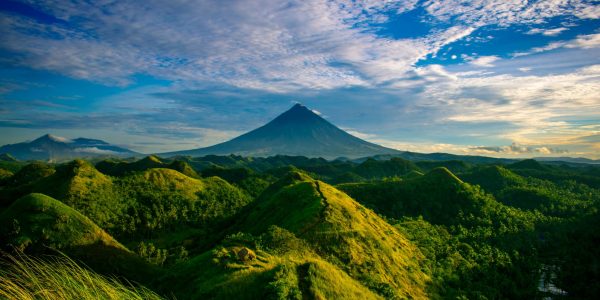 Beautiful landscape of Mayon Volcano amidst verdant hills in Bicol, Philippines.